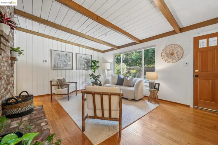 Living room featuring beam ceiling and light wood-type flooring