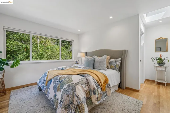 Bedroom with a skylight, light wood-type flooring, and recessed lighting