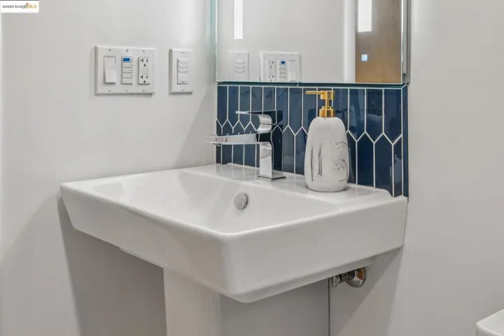 Bathroom featuring a sink and backsplash