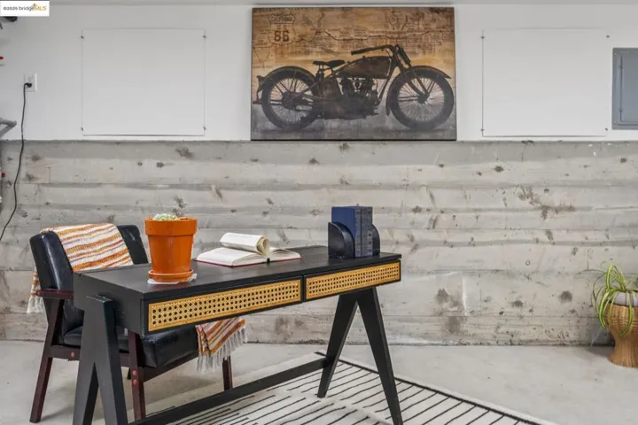 Office space featuring unfinished concrete floors and electric panel