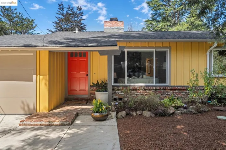 Doorway to property featuring board and batten siding, a shingled roof, a chimney, and stone siding