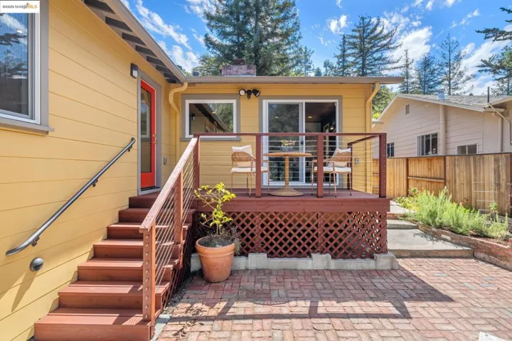 Rear view of property featuring a chimney, a deck, and a patio area