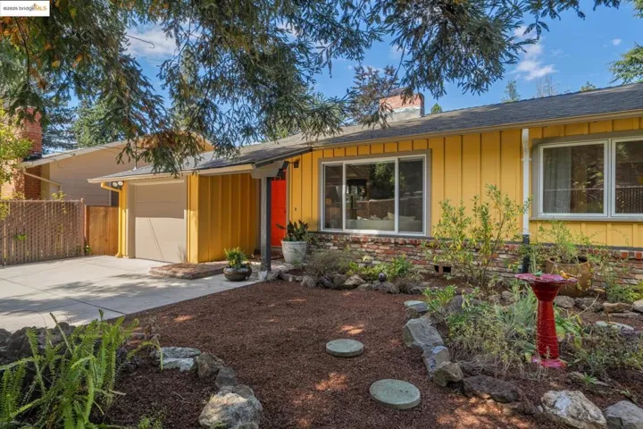 View of front of home featuring board and batten siding, a chimney, concrete driveway, a shingled roof, and an attached garage