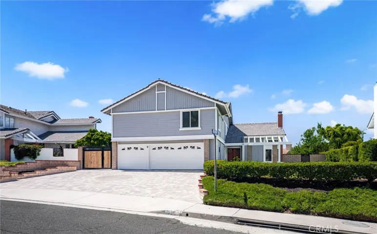 Front view of property with custom paver driveway, update front fence and locking gate, 3 car garage and room for additional parking.