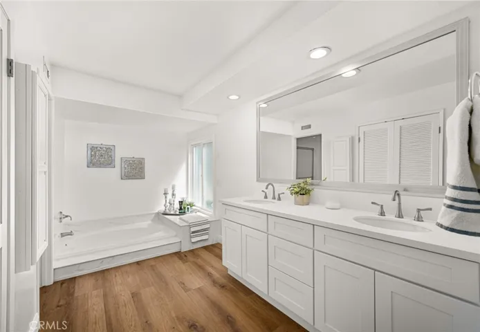 Primary Bathroom with new cabinetry, dual sinks, quartz counters, soaking tub and walk-in closet.