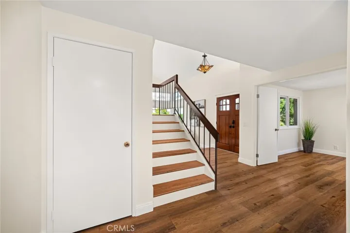 View of front door, staircase, first floor bedroom or office and storage closet.