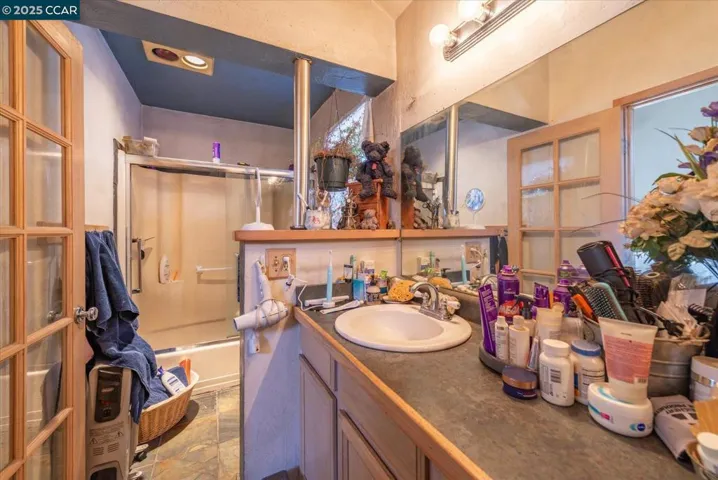En suite bathroom featuring a walk-in shower, extended vanity, and large mirrored wall, designed for both comfort and convenience.