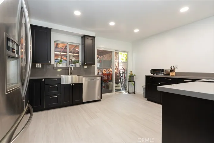 Dark Shaker cabinets in the kitchen, and smooth quartz countertops.