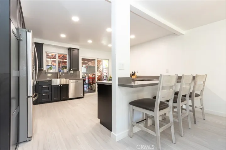 Chef's kitchen with stainless steel appliances, loads of counter space, pantry cupboard and breakfast bar.