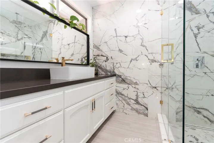 Smashing primary bath with vessel sink and glass enclosed shower, plus gorgeous finishes and hardware.