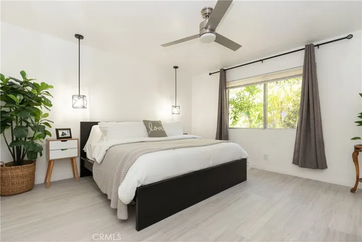 Tranquil primary suite with pendant lighting and ceiling fan.