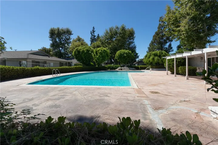 Expansive pool nearby with a clubhouse and spacious deck.