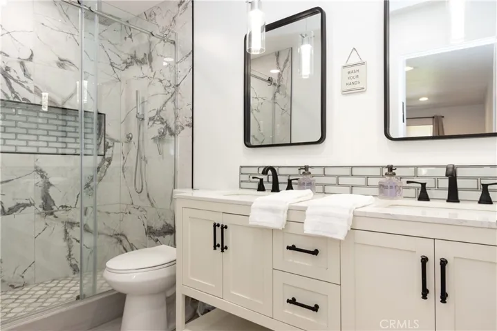 Secondary bedroom ensuite bath has a free standing vanity with dual sinks, and an extra large walk-in shower.