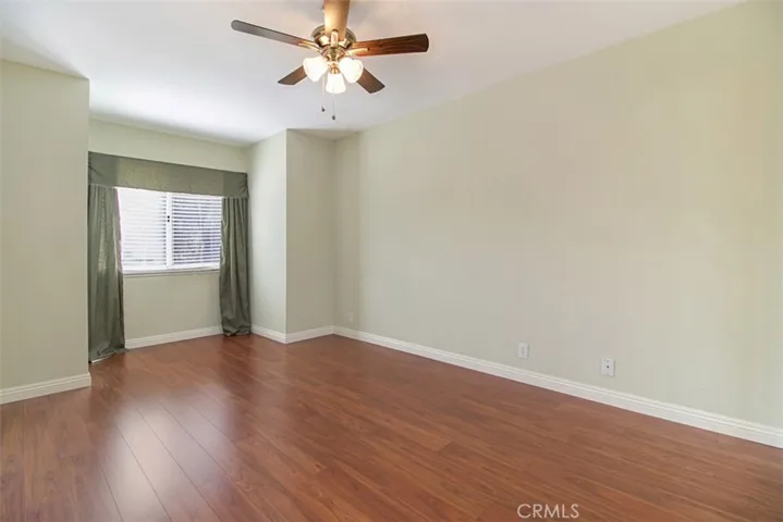 Third bedroom has wood floors and ceiling fan.