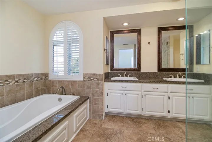 Master bath has Jacuzzi tub, dual sinks in vanity