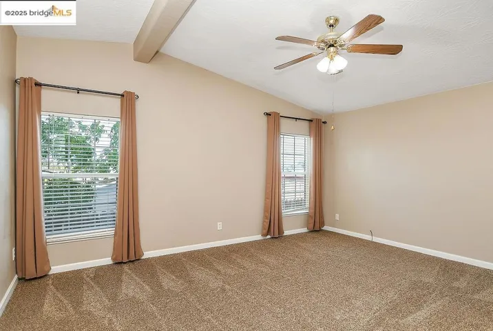 Unfurnished room featuring carpet floors and ceiling fan