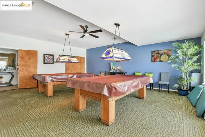 Recreation room with billiards table, a ceiling fan, and carpet