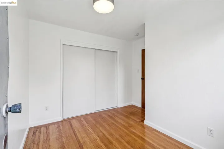 Unfurnished bedroom featuring wood finished floors and a closet