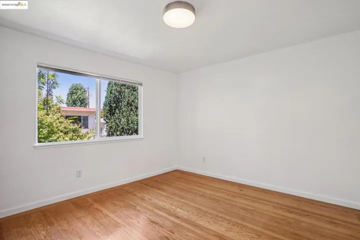 Spare room with baseboards and light wood-style flooring