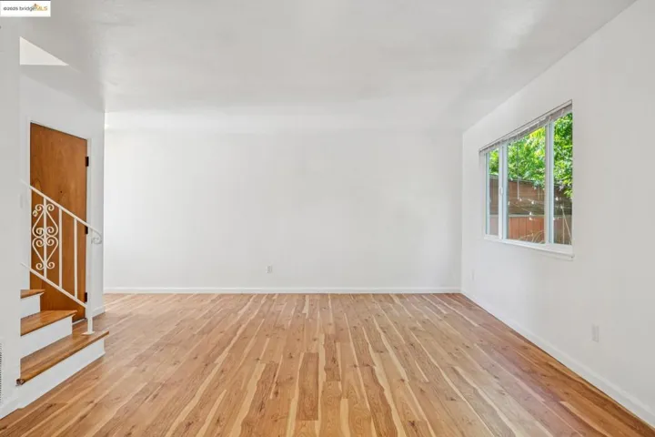 Empty room featuring light wood-style flooring and stairs
