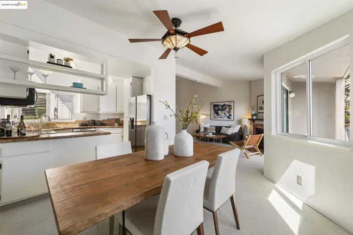 Dining area with light colored carpet and ceiling fan
