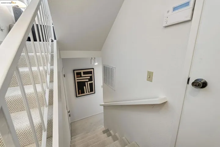 Stairs with carpet flooring and vaulted ceiling