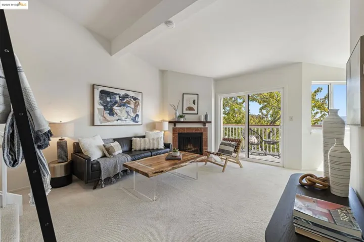 Carpeted living room with beam ceiling and a fireplace