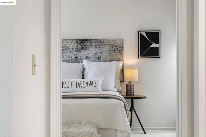 Bedroom featuring a textured wall and baseboards