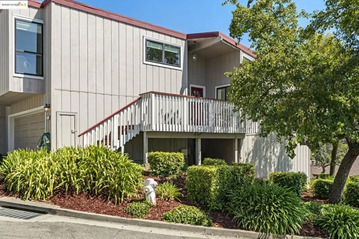 Back of house with stairs and an attached garage