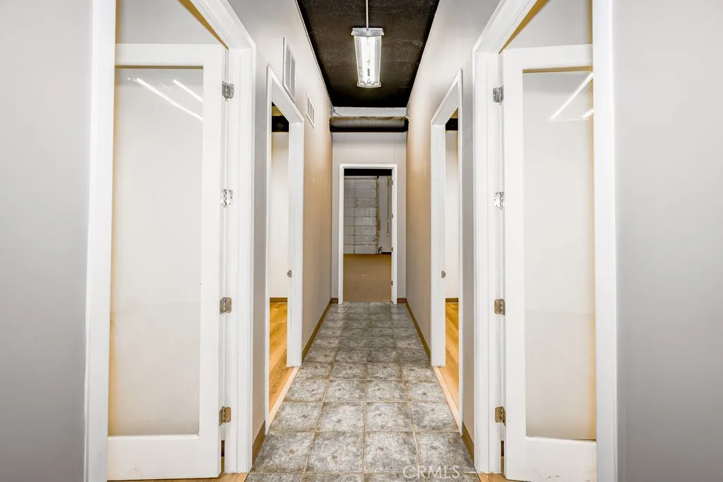 hallway with doors to 5 offices and large warehouse