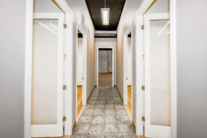 hallway with doors to 5 offices and large warehouse
