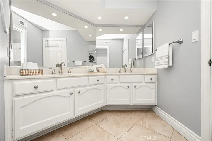 Spacious hall bathroom with dual sinks and extra cabinetry