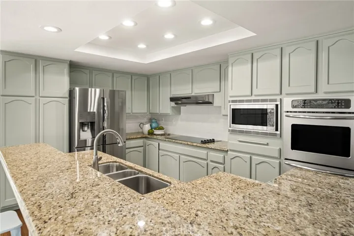 Soft sea foam painted cabinets have been updated with pull outs and subway tiles