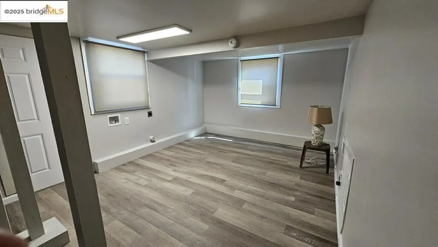 Below grade area with light wood-type flooring and baseboards