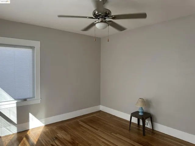 Unfurnished room featuring wood finished floors and ceiling fan