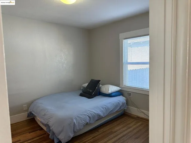 Bedroom with wood finished floors and baseboards