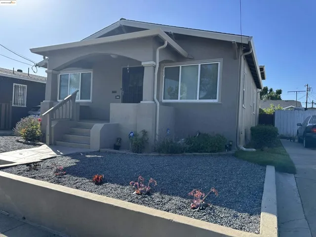 Bungalow-style home with stucco siding and covered porch