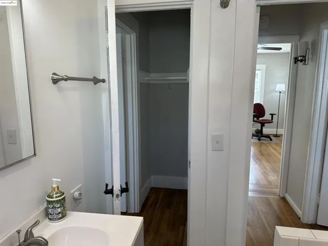 Bathroom with wood finished floors, vanity, and a ceiling fan