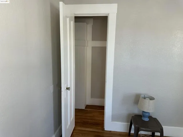 Corridor featuring dark wood finished floors and a textured wall