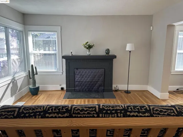 Detailed view of wood finished floors, a fireplace, and a textured ceiling