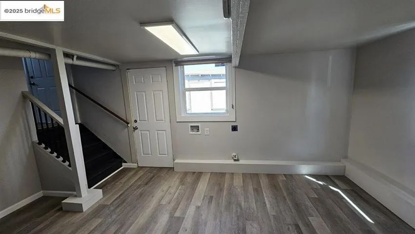 Basement featuring dark wood finished floors and stairway