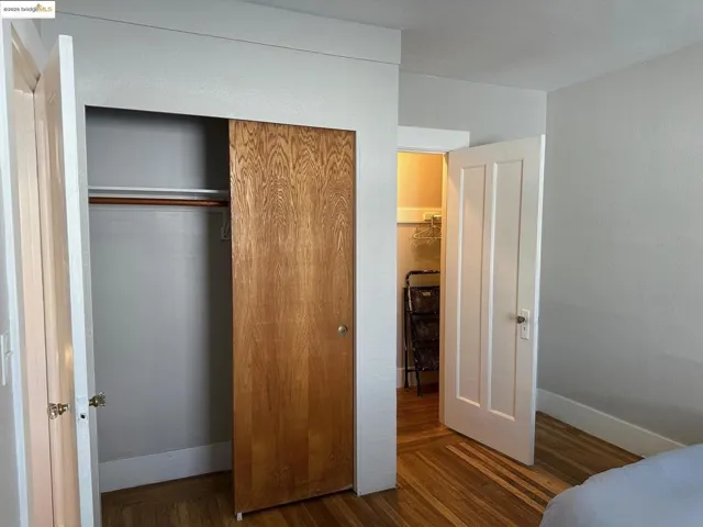 Bedroom featuring wood finished floors and a closet