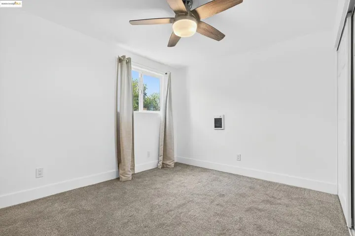 Unfurnished room featuring carpet and ceiling fan