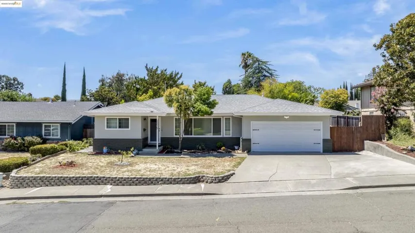 Single story home with brick siding, driveway, and a garage