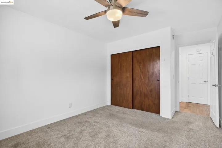 Unfurnished bedroom featuring carpet flooring, a closet, and ceiling fan