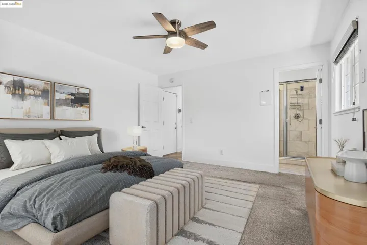 Carpeted bedroom featuring connected bathroom and ceiling fan