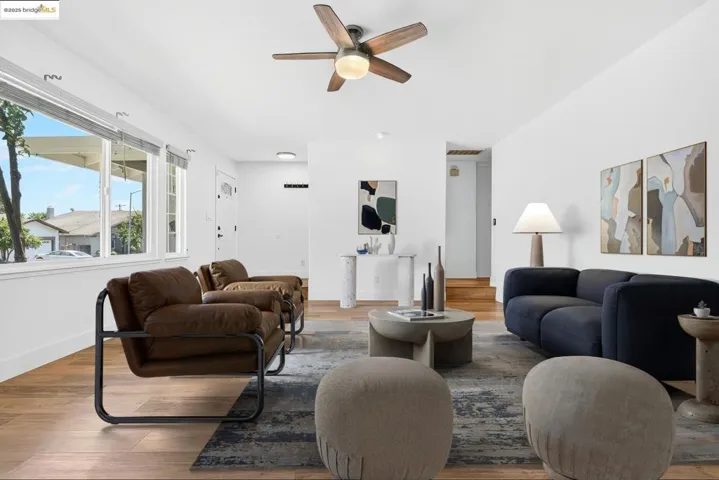 Living area with ceiling fan and wood finished floors