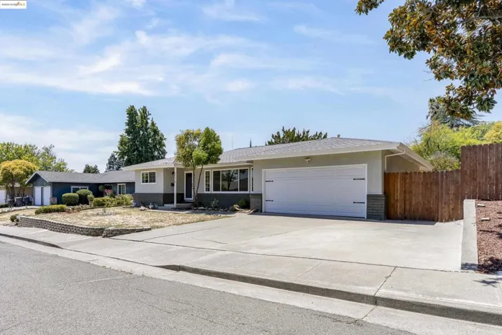 Ranch-style home featuring concrete driveway, brick siding, and a garage
