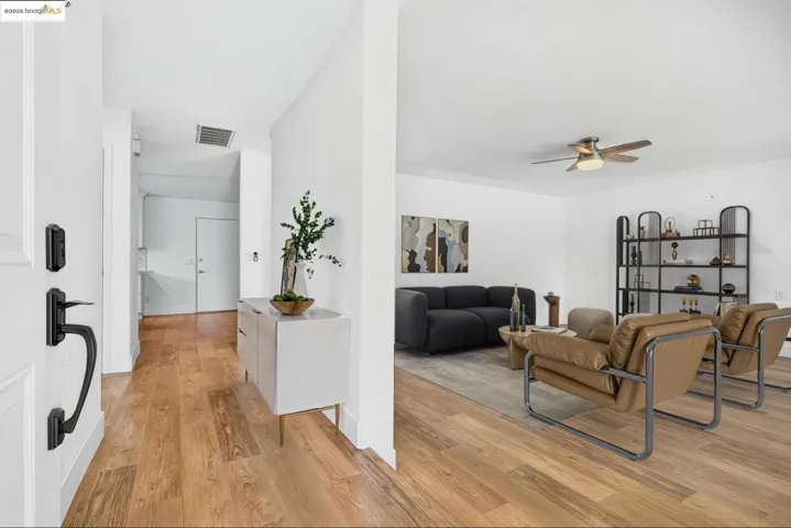 Living area with ceiling fan and light wood-type flooring