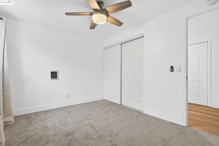 Unfurnished bedroom with carpet flooring, a closet, and a ceiling fan